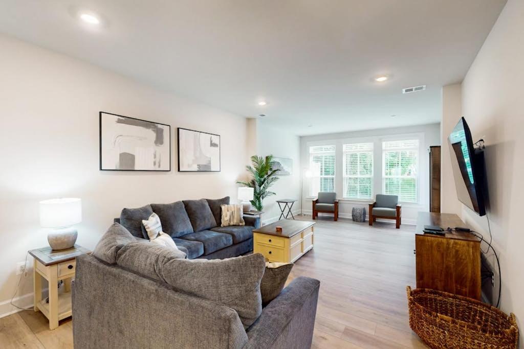 a living room with a couch and a tv at The Peninsula --- 22308 Dune Cir 74 in Millsboro