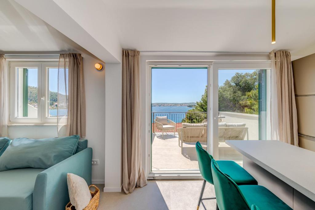 a living room with a blue couch and a large glass door at 7 Olives Luxury Suites in Rogoznica