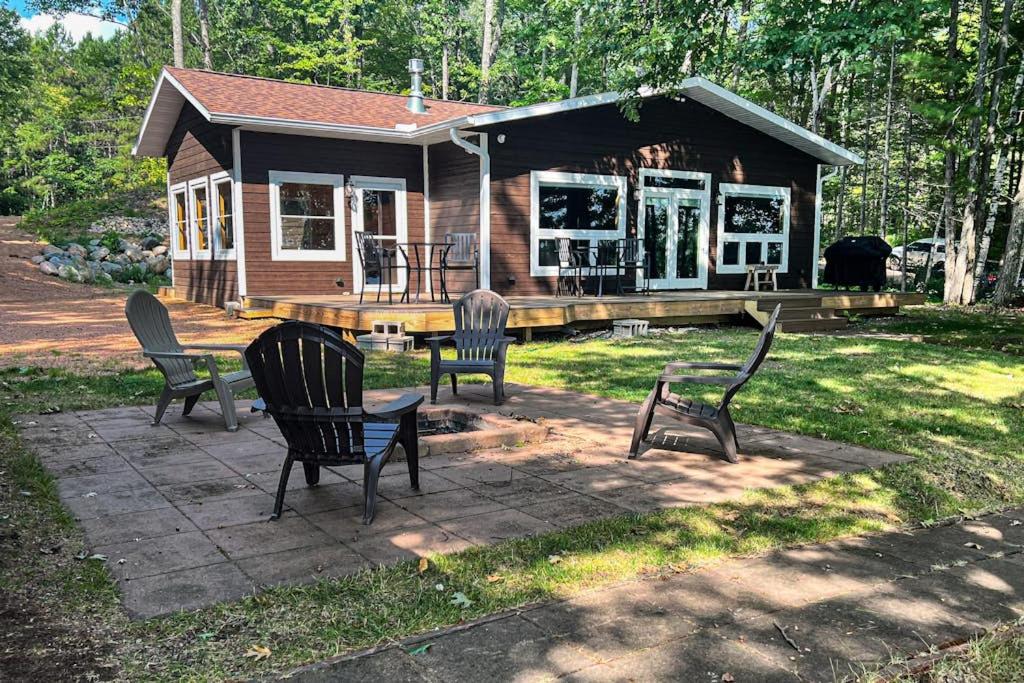 a small house with chairs in front of it at Pair-a-Docks Landing in Minocqua