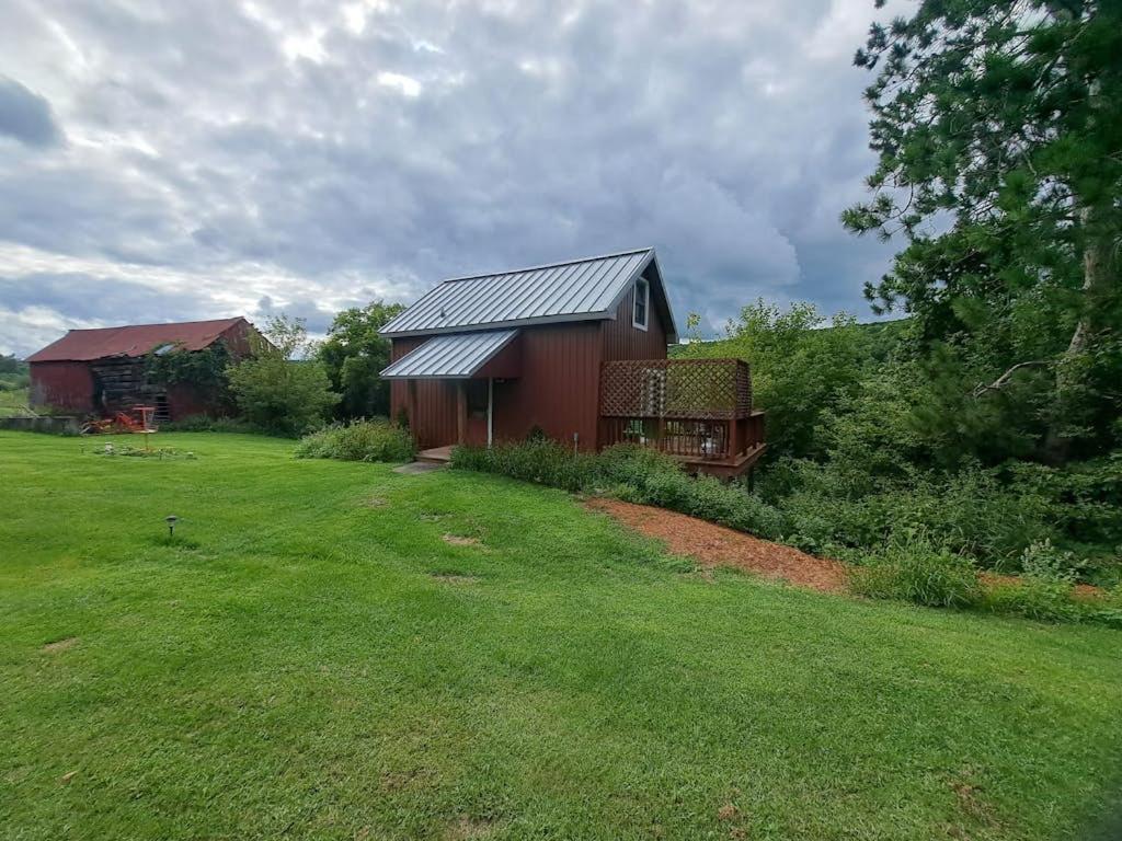 a red barn in a field with a yard at Running Fox Farm in Baraboo