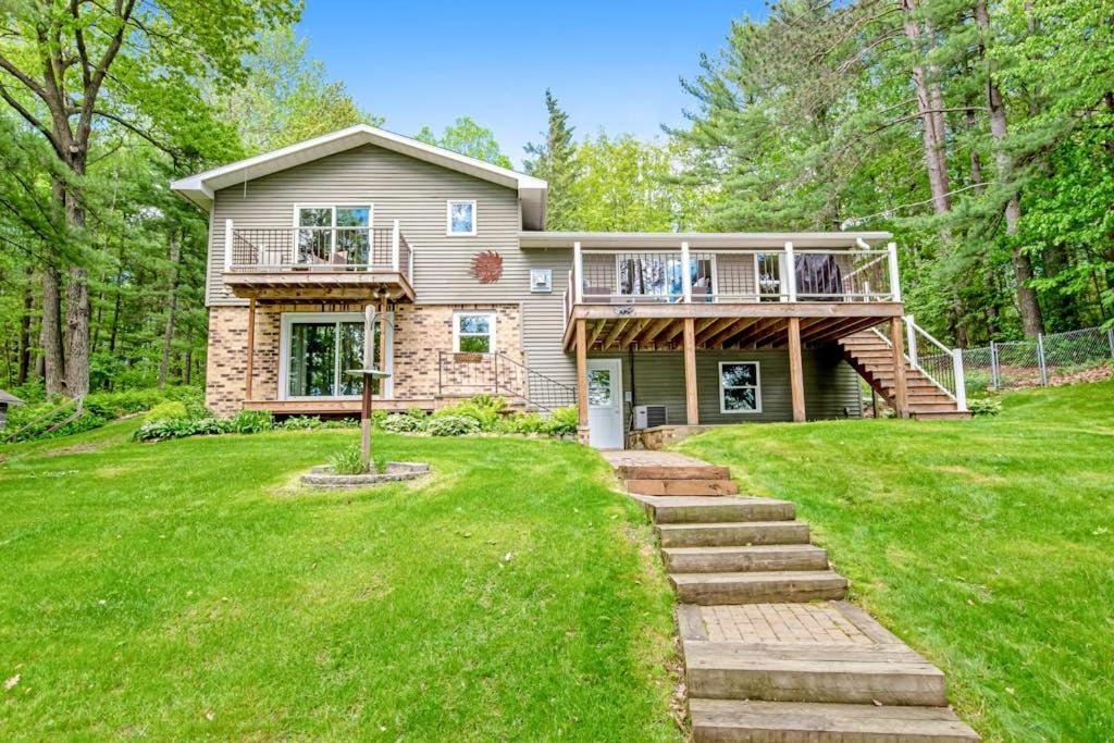 a house with a deck and a balcony at Road Lake Escape in Tomahawk