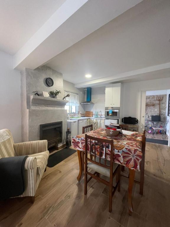 a kitchen and living room with a table and a couch at La CASA de mis PADRES 2 in Arahuetes
