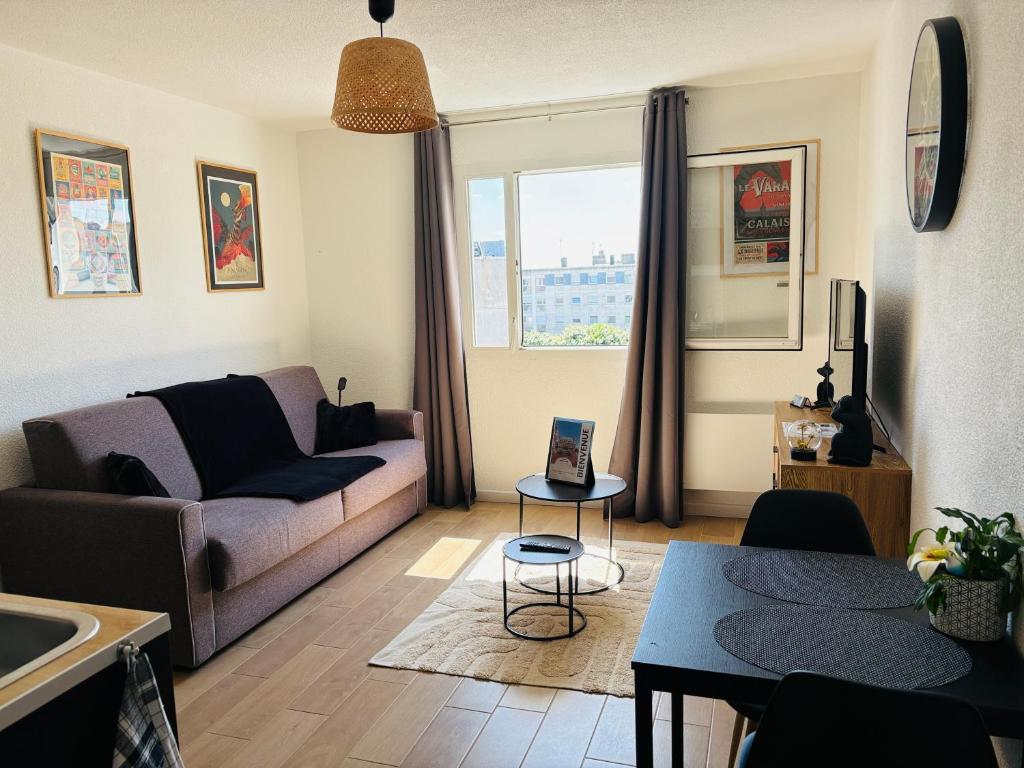 a living room with a couch and a table at Studio calais la plage in Calais