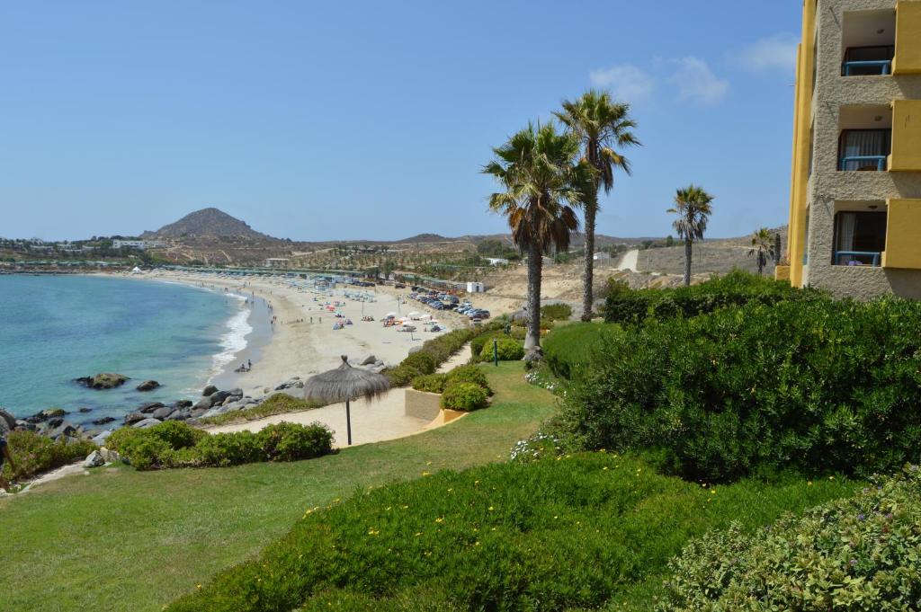 vista su una spiaggia con palme e su un edificio di Departamento Playa Blanca a Playa Blanca