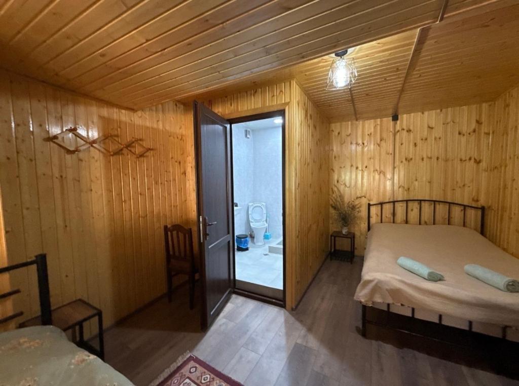a bedroom with a bed and a bathroom with a toilet at SAOTI Guest house in Shatili
