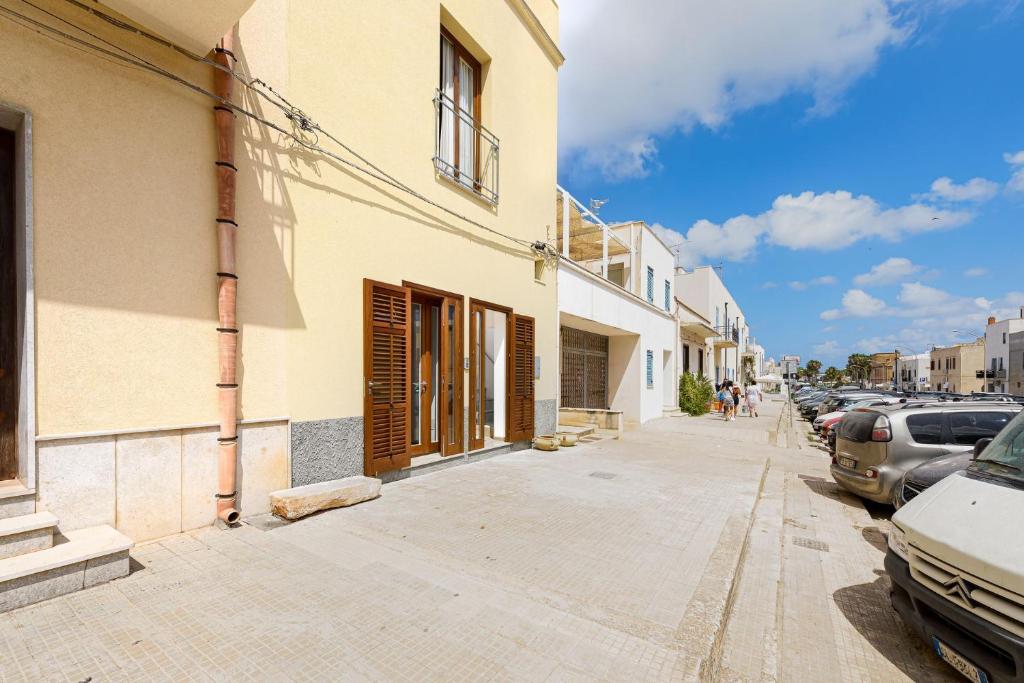 a street with cars parked on the side of a building at Sinedda Sole in San Vito lo Capo