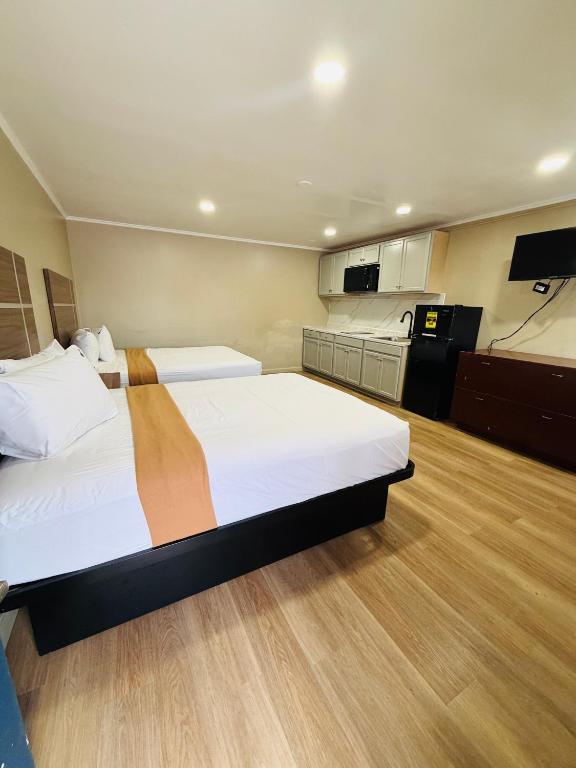a hotel room with two beds and a kitchen at AC Suites in Atlantic City