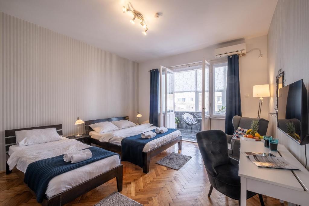 a hotel room with two beds and a desk and a desk at Selection Rooms in Belgrade