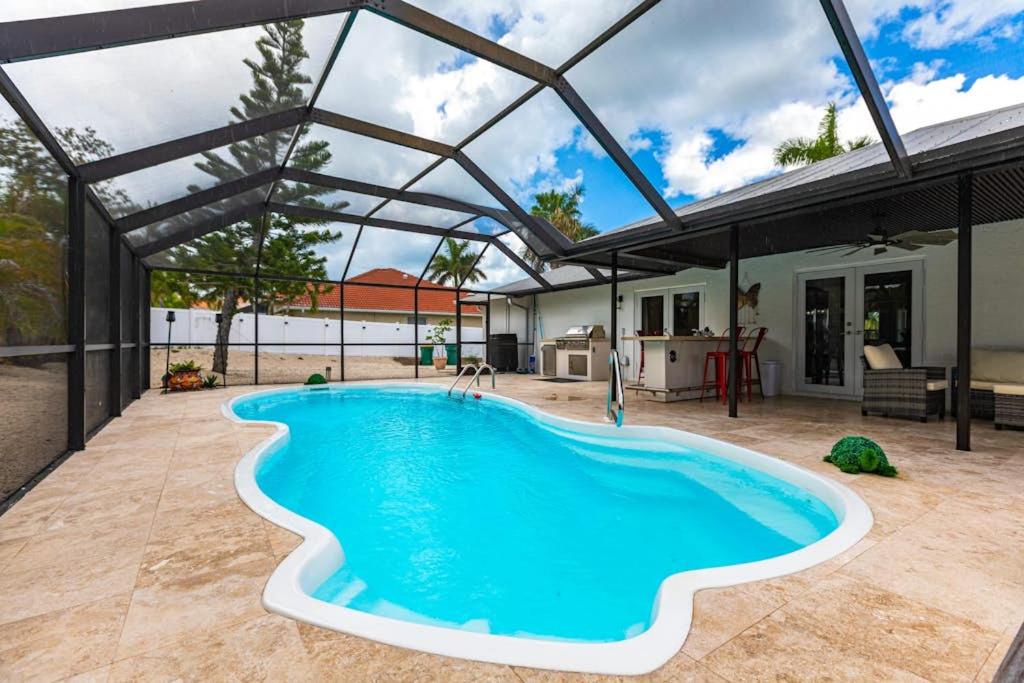 a swimming pool in a patio with a large metal roof at Vanessas Villa in Marco Island