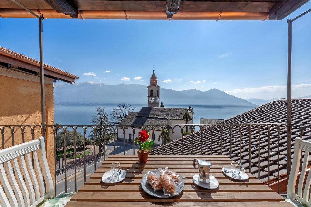 a table on a balcony with a view of the water at Splendid Lake View in Ronco sopra Ascona