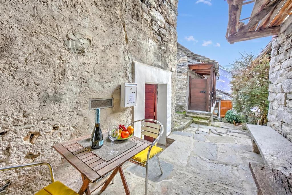a wooden table with a bowl of fruit on a patio at Rustico Caterina - Corippo- Happy Rentals in Corippo