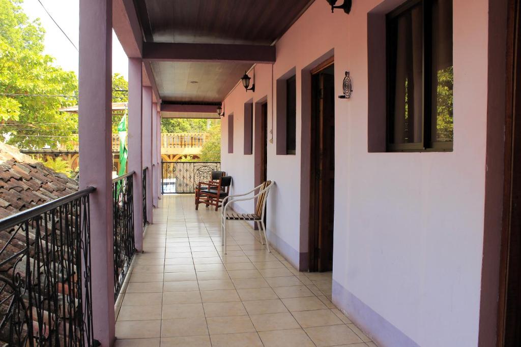 a balcony of a house with chairs and a table at The Landing Hotel And Restaurant in Moyogalpa