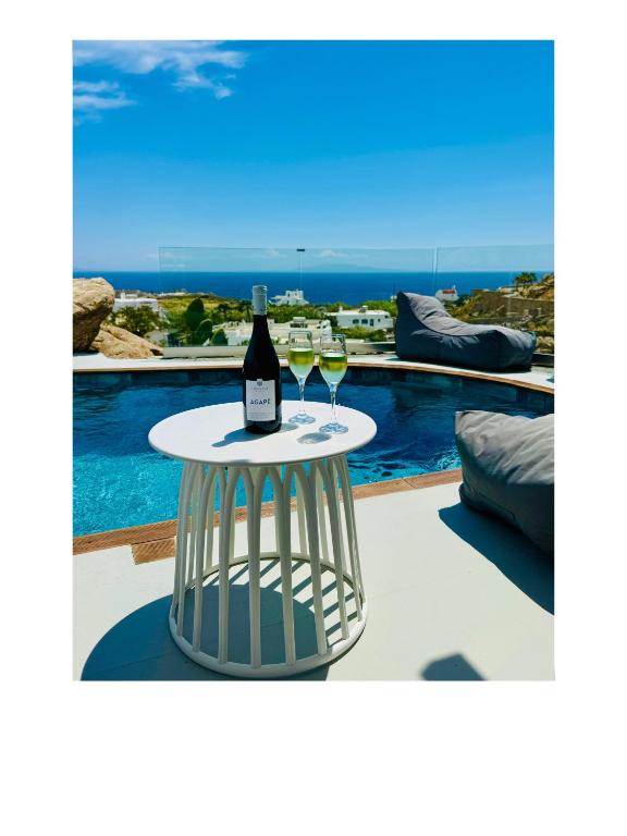 a bottle of wine on a table next to a pool at Psaros Village Mykonos in Platis Gialos