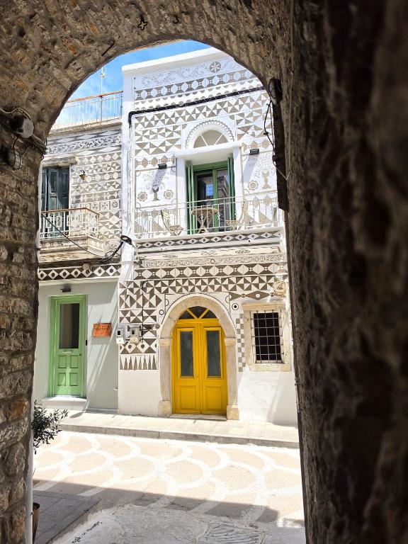 a yellow door on a building with a balcony at Mastiha Essence Residence in Pyrgi