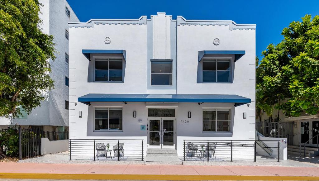 a white building with a blue awning at Casa Collins in Miami Beach