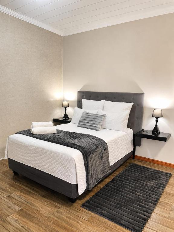 ein Schlafzimmer mit einem großen Bett und zwei Lampen in der Unterkunft Scarlett's in Welgelegen
