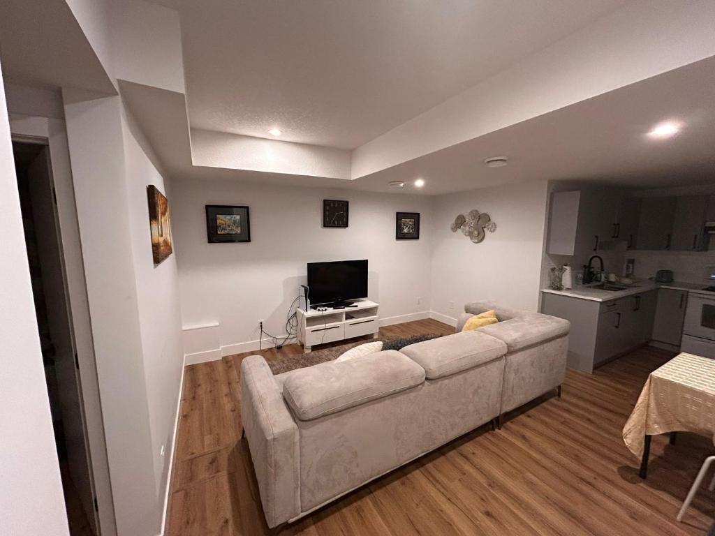 a living room with a couch and a flat screen tv at Havre de paix in Fort Saskatchewan