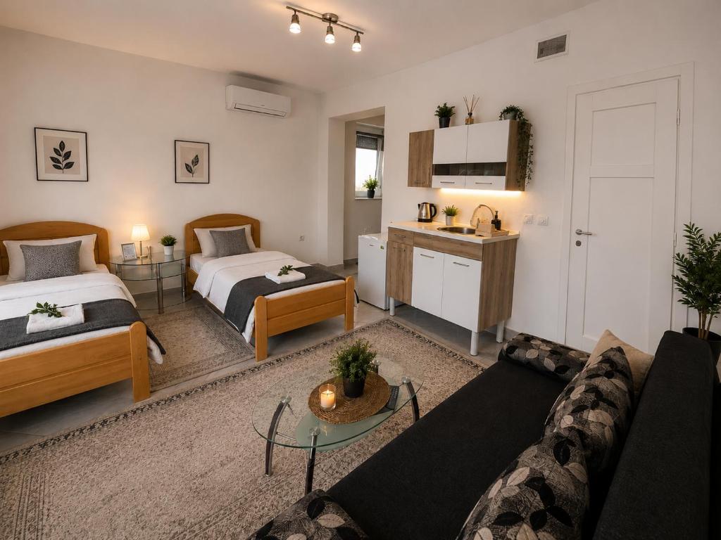 a living room with two beds and a couch at Apartmani Velić in Bugojno