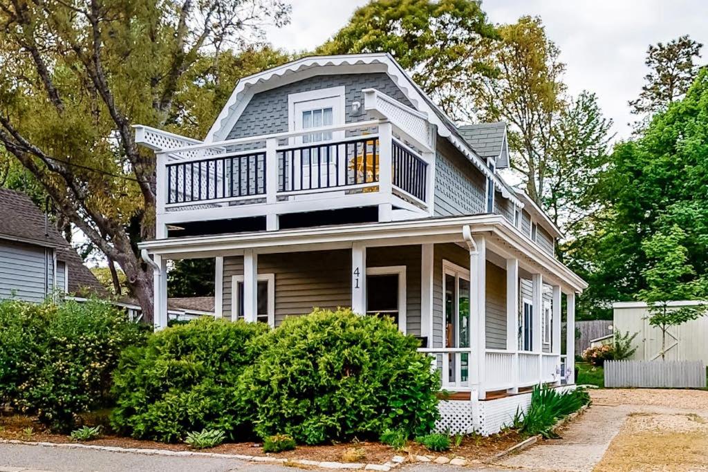 a white house with a balcony on top of it at Oak Bluffs Cottage in Oak Bluffs