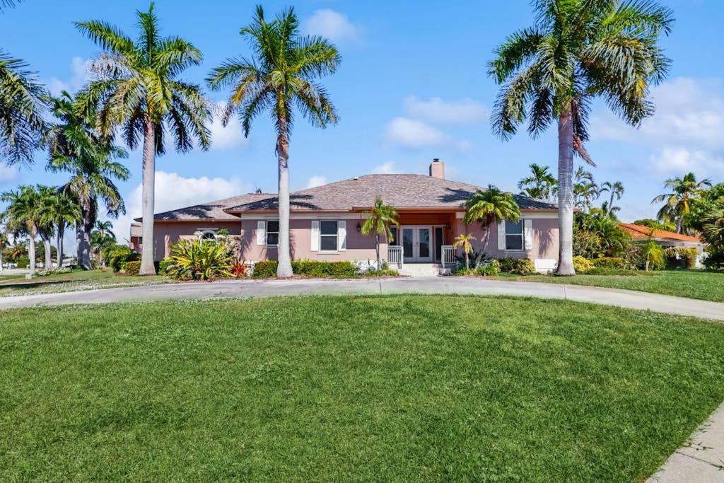 a house with palm trees in front of it at Tranquil Haven in Marco Island