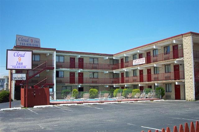 a large building with chairs and a sign in front of it at Cloud 9 Inn - Beach Hotel in Seaside Heights