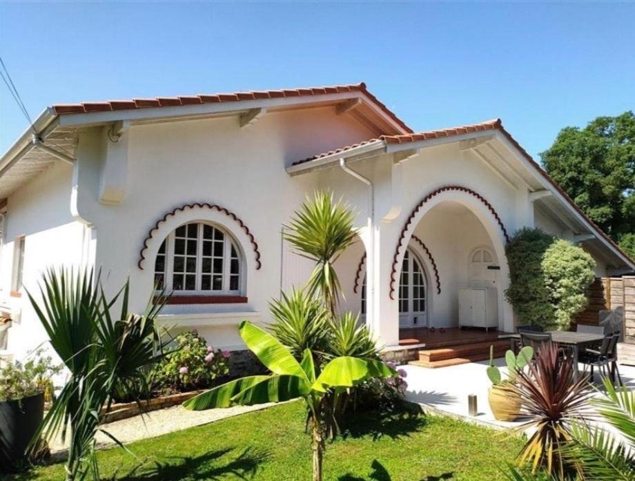 a white house with a garden in front of it at Belle maison basco landaise avec jacuzzi in Labenne