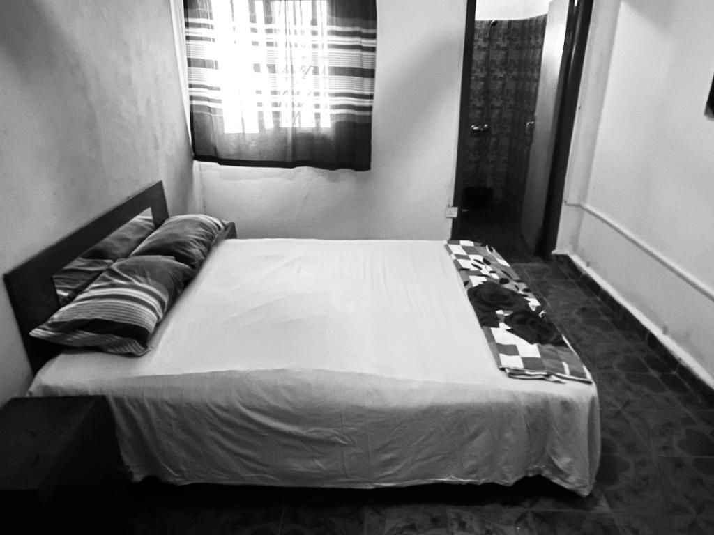 a black and white photo of a bed in a bedroom at Sumanya guest house 6 in Sukuta
