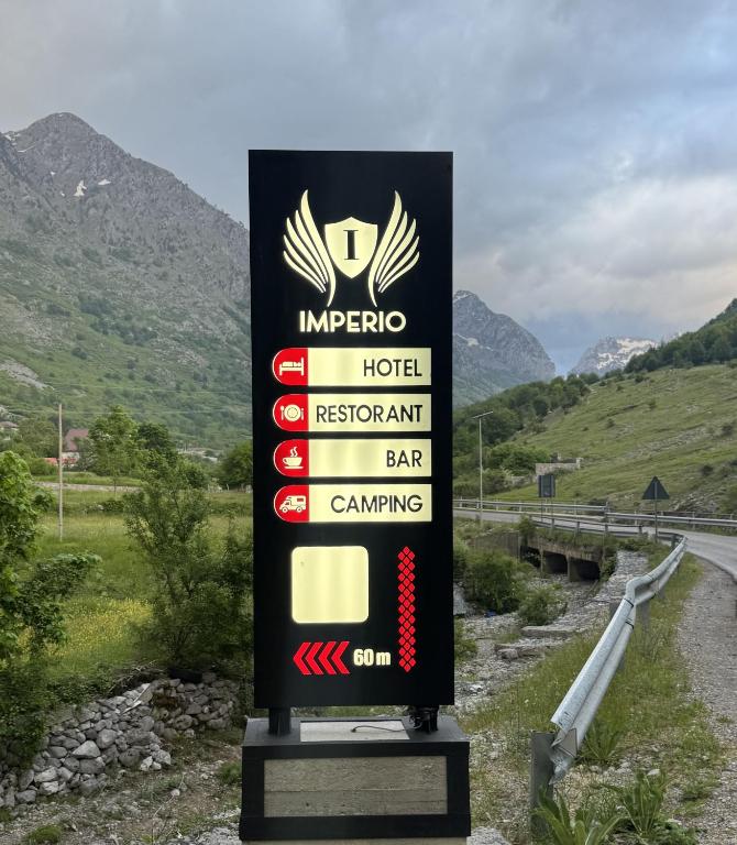 a sign for a hotel next to a road at Imperio Boge Hotel in Bogë