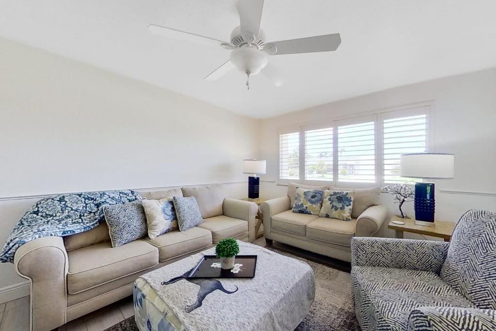a living room with a couch and a ceiling fan at Southwest Florida Sanctuary in Cape Coral