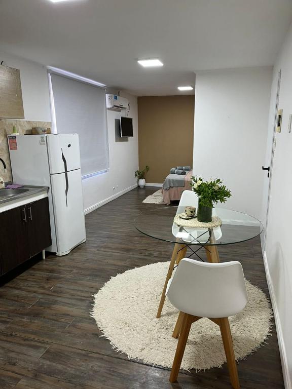 a kitchen with a table and a white refrigerator at Monoambiente Lavalle Lujan in Luján
