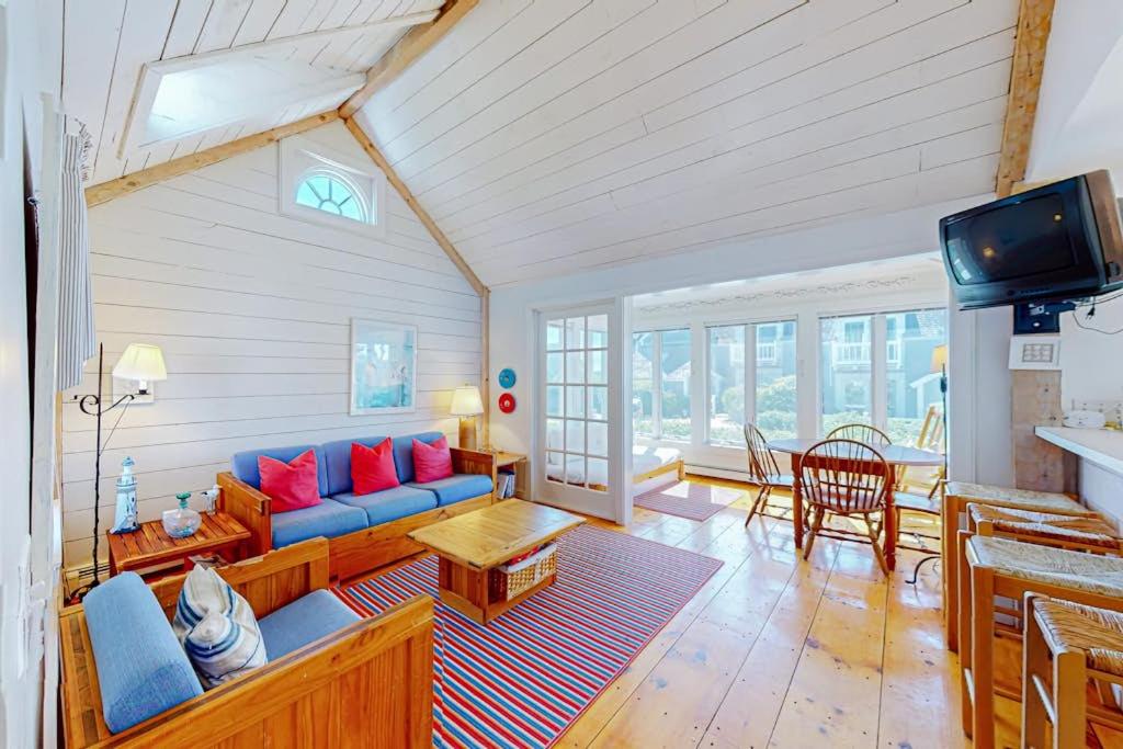 a living room with a blue couch and a table at Maushop By The Sea in Mashpee