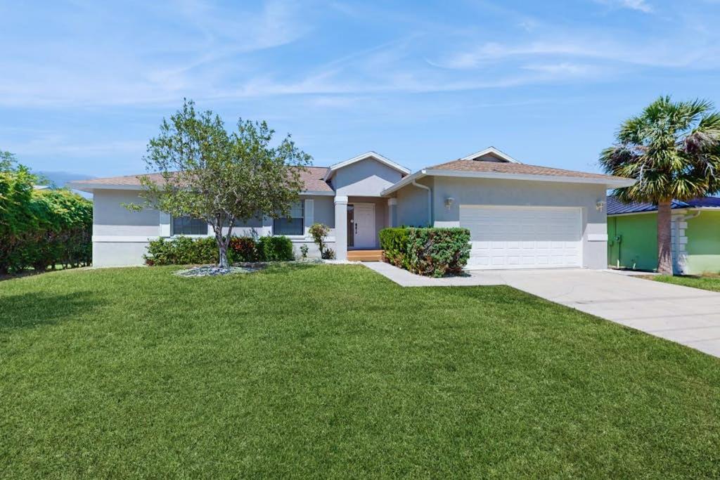 a house with a green lawn in front of it at Marco Sands in Marco Island
