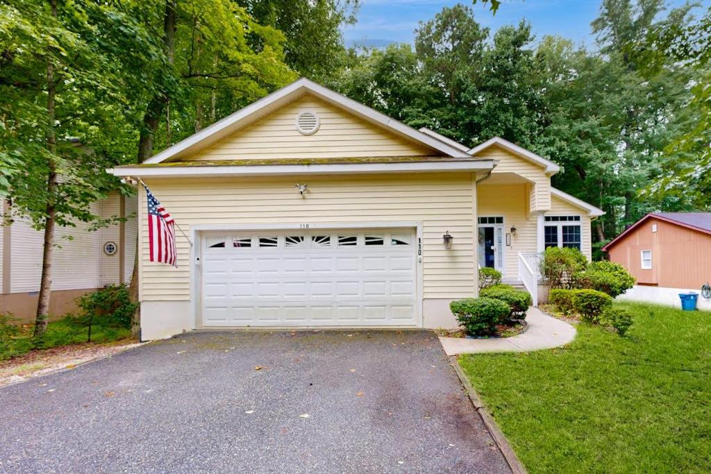 a house with a garage with a flag on it at Coral Shells in Ocean Pines