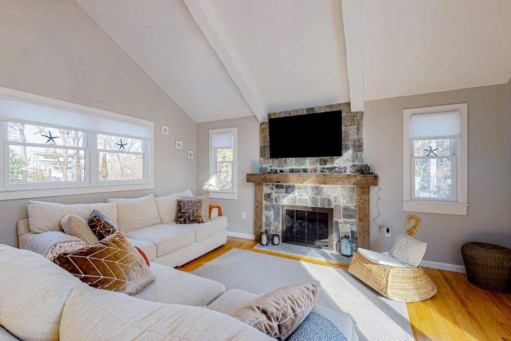 a living room with a couch and a fireplace at Seabury Serenity in New Seabury
