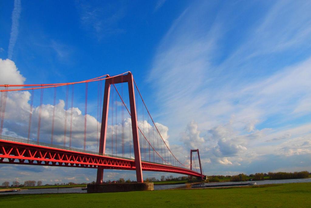 a red bridge in the middle of a field at Modern appartement nabij boulevard in Emmerich