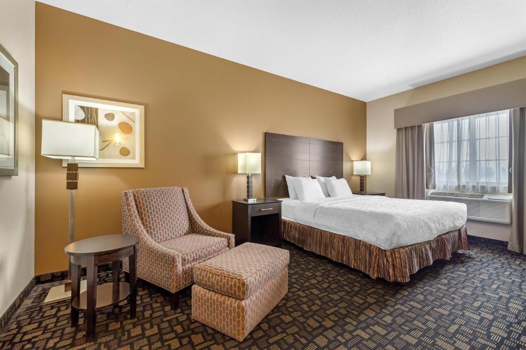 a hotel room with a bed and a chair at Best Western Plover-Stevens Point Hotel & Conference Center in Plover
