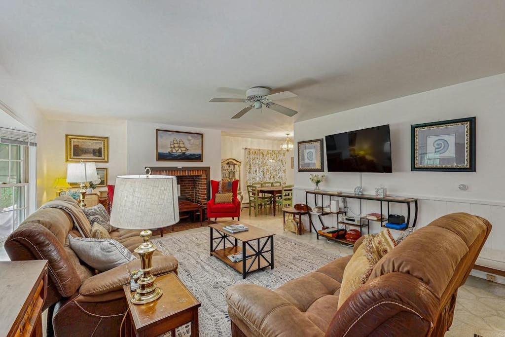 a living room with couches and a flat screen tv at The CAVU Mansion on Bellevue in Oklahoma Heights