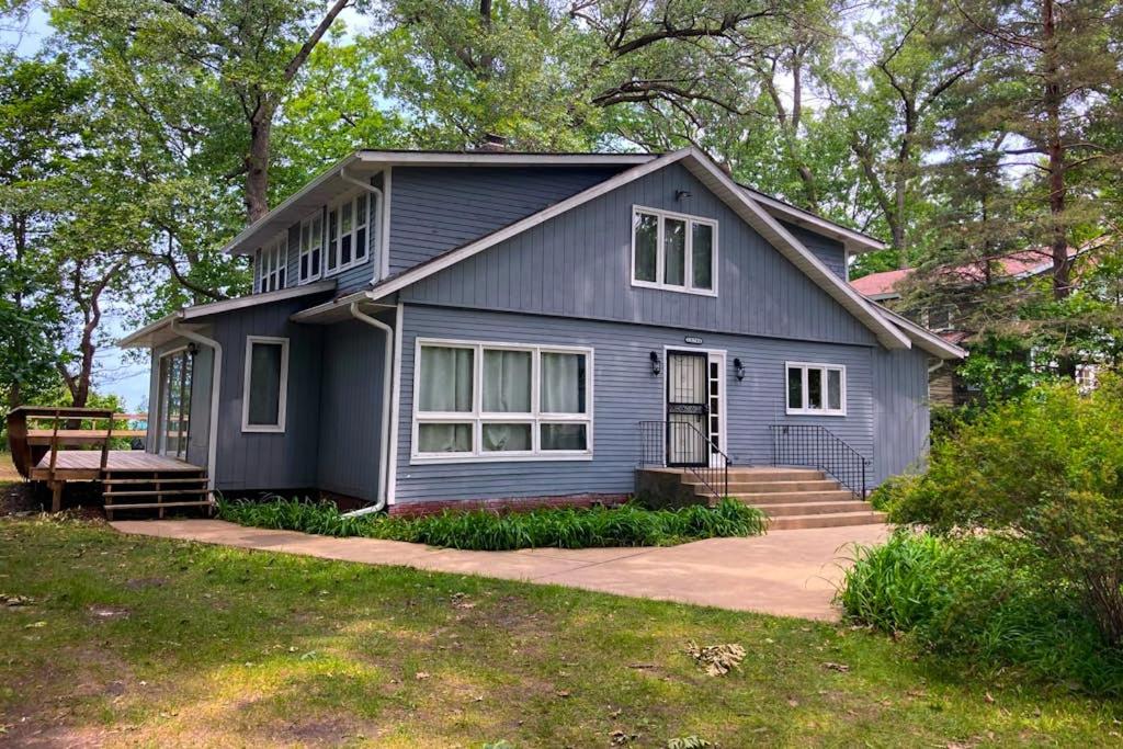 a blue house with a porch and stairs at Casual Lake Living in Union Pier