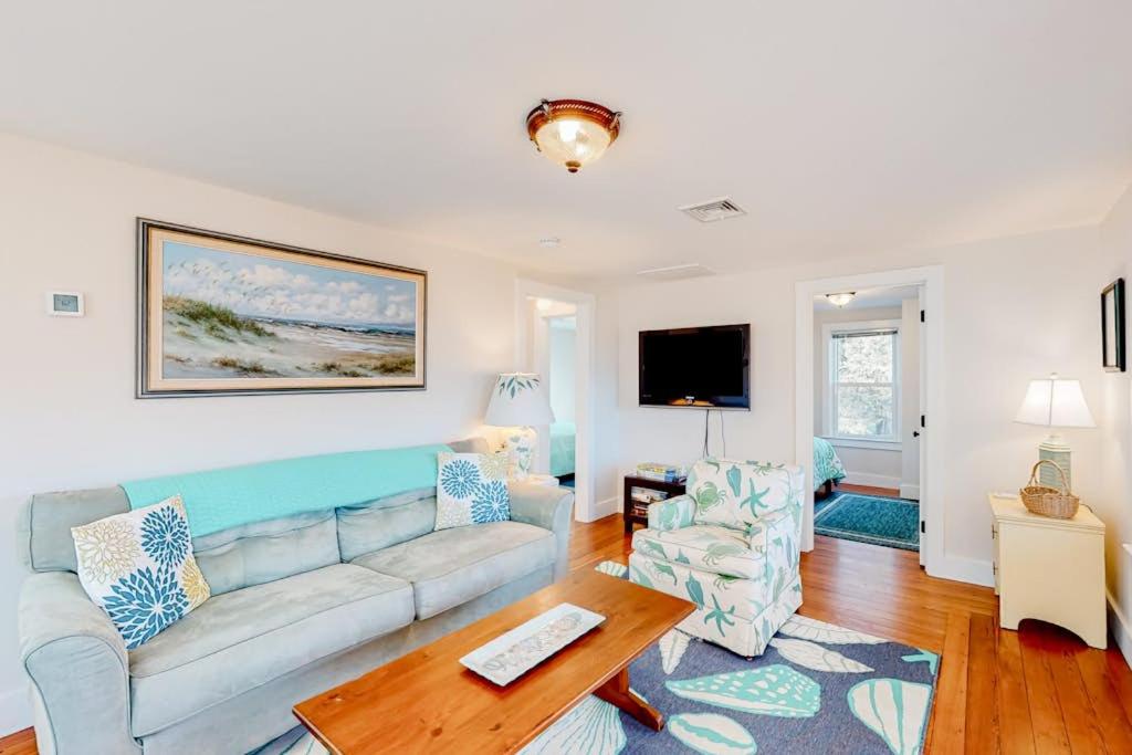 a living room with a couch and a table at Cataumet Cottage in Bourne
