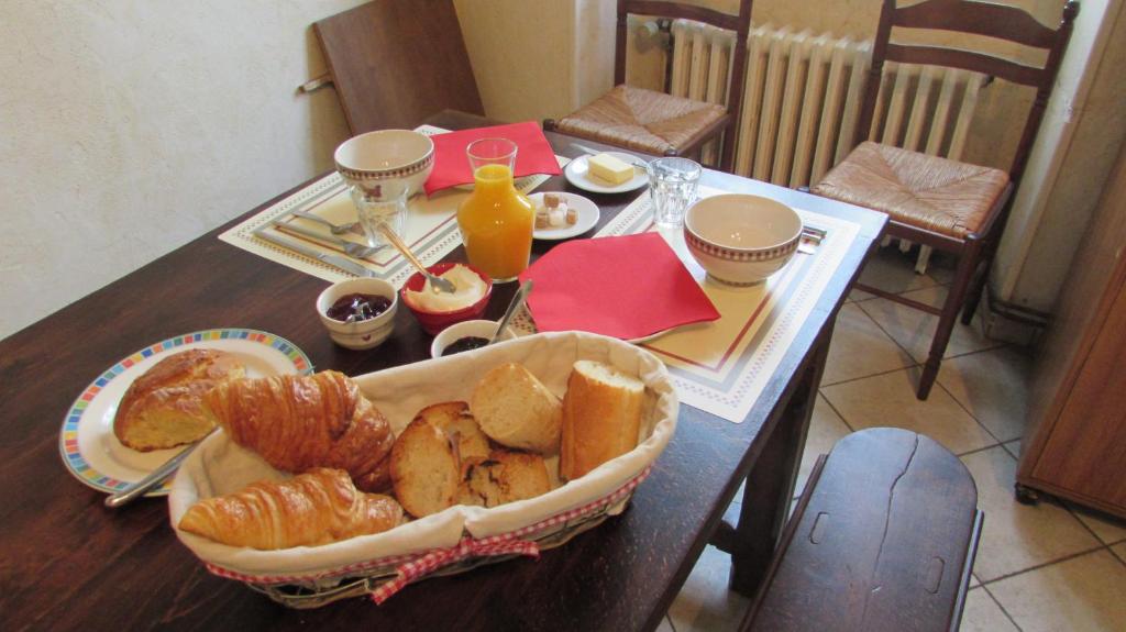 Auberge Les Volcans في مورات: طاولة عليها سلة من الخبز والمعجنات