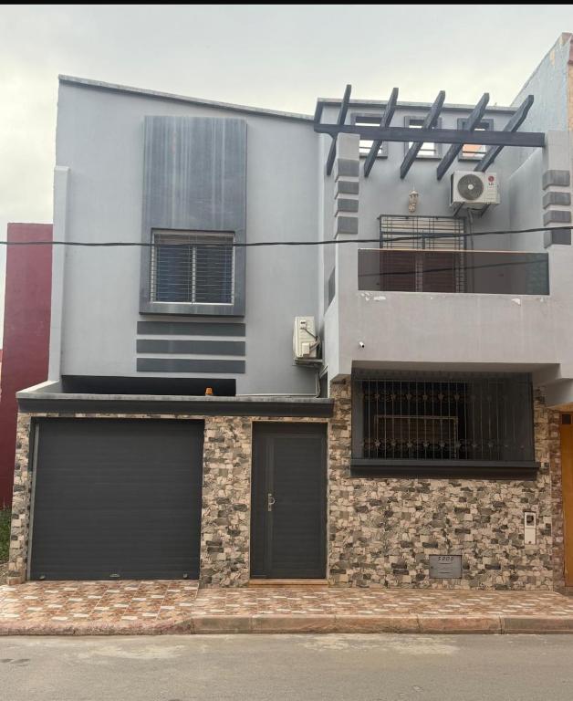a building with two garage doors and a balcony at Villa Familiale Exception in Saïdia