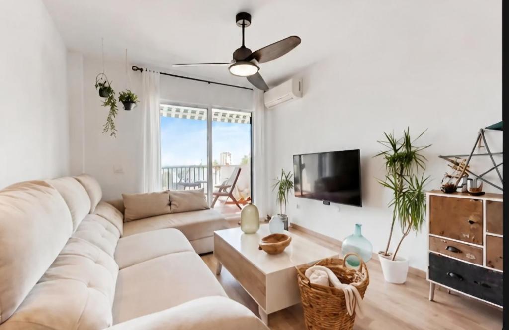 a living room with a white couch and a ceiling fan at APARTAMENT MIJAS BEACH, ÁNGEL in La Cala de Mijas