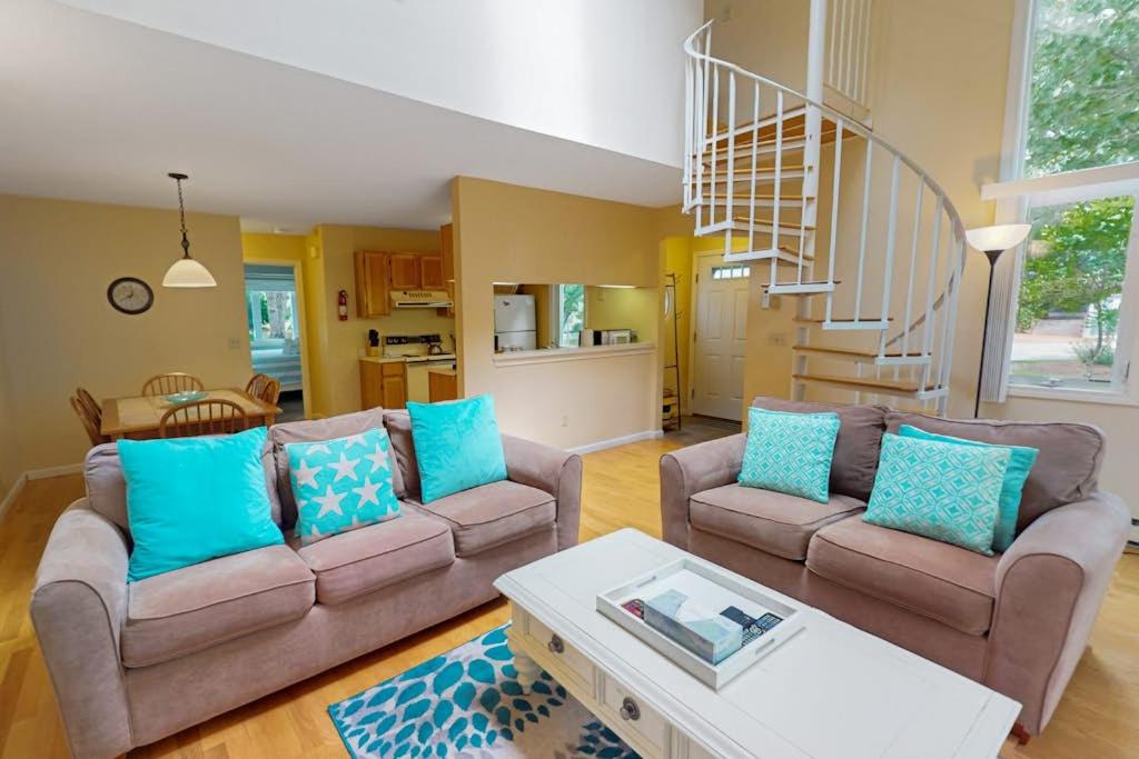 a living room with two couches and a staircase at Ocean Edge Retreat in Brewster