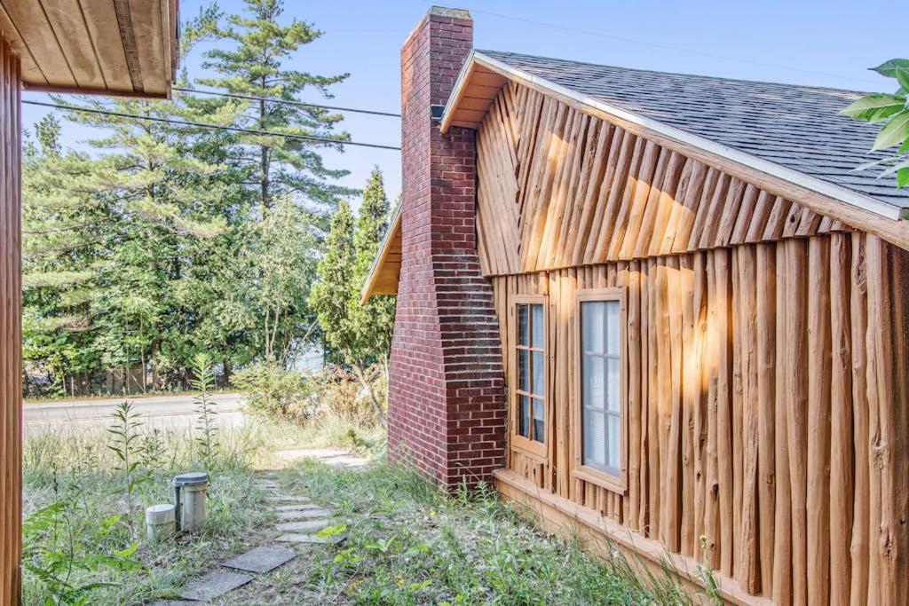 a brick building with a window next to a house at Cedar Cot & Cedar Tot in Beulah