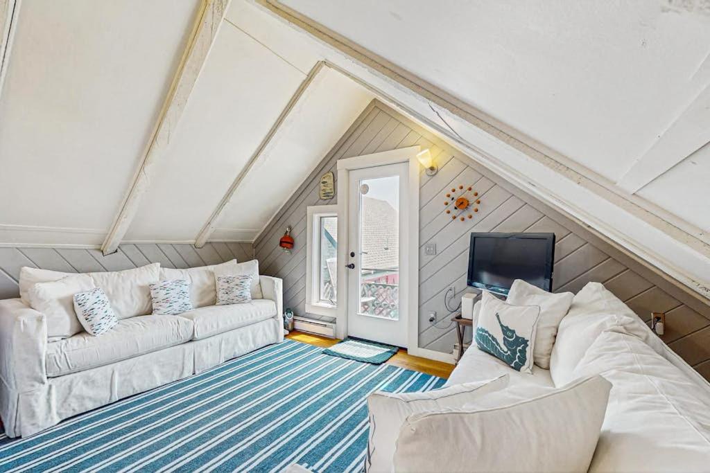 a living room with two white couches and a tv at Monument View in Provincetown