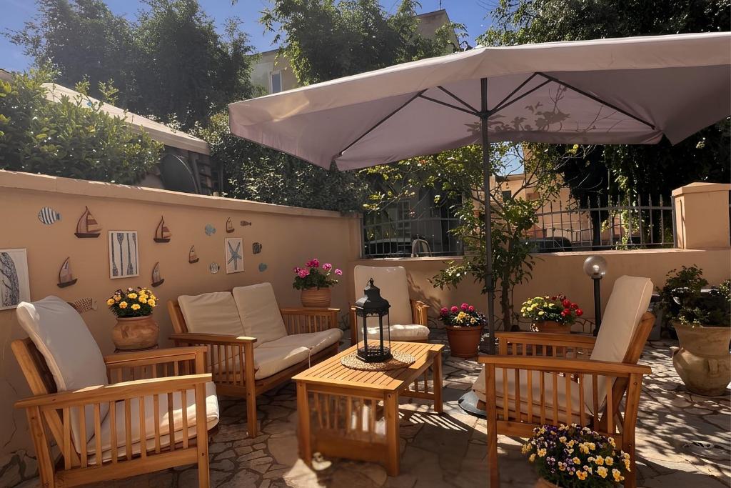 a patio with a table and chairs and an umbrella at Macri Alghero in Alghero