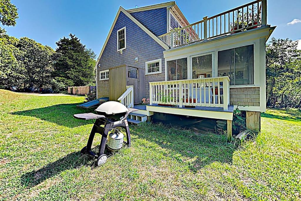 a house with a grill in the yard at Brookview Bungalow in South Wellfleet