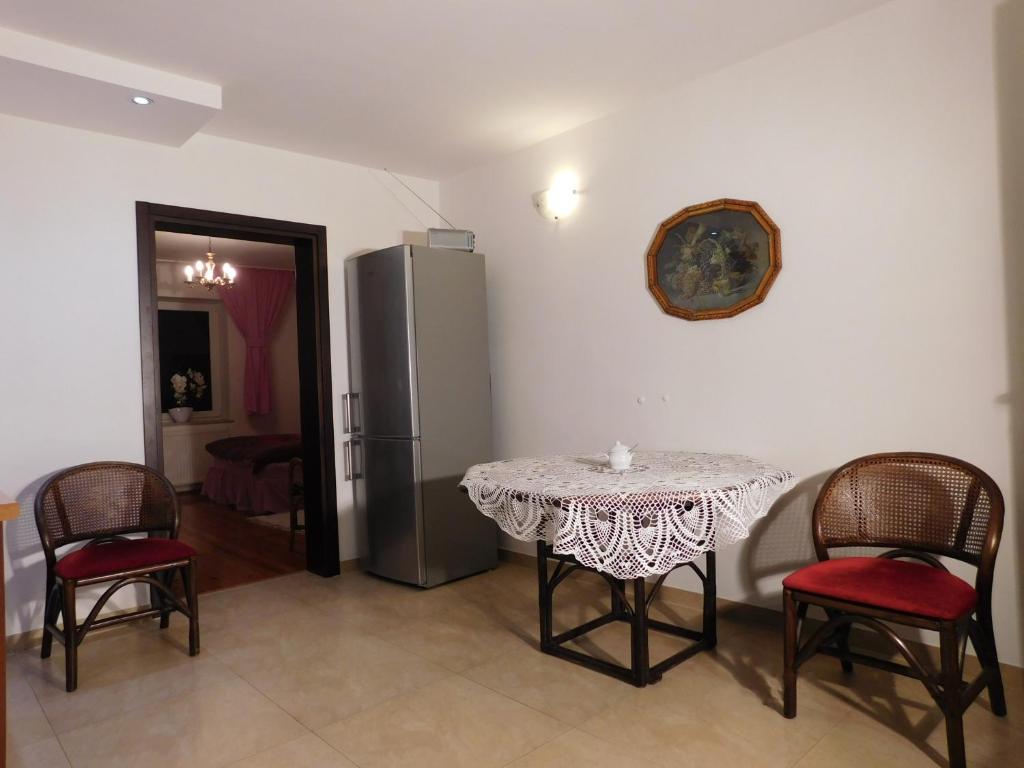 a table and chairs in a room with a refrigerator at Agroturystyka pod Czarną Sosną in Biały Ług