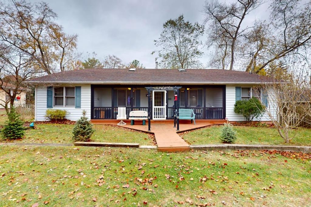a white house with a porch and a yard at Four Bedrooms & a Beach in Lakeside