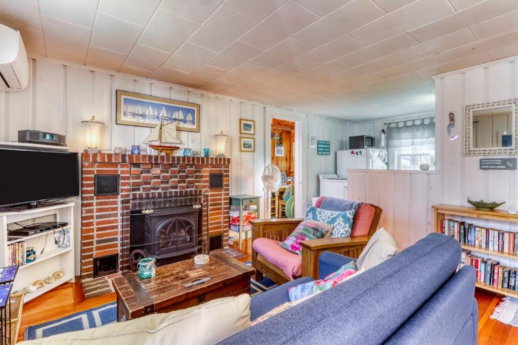 a living room with a blue couch and a fireplace at Sea la Vie in Harwich